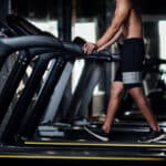 Muž trénuje na páse – bežecký pás a stacionárny bicykel